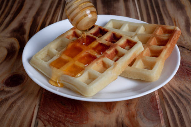 istock Honey pouring from dipper on Belgian waffles 1307216343