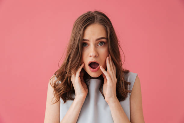istock Shocked young woman standing isolated 1307216769
