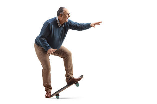 Full length profile shot of a corpulent mature man on a skateboard isolated on white background