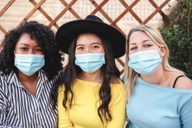 istock Happy multiracial friends taking selfie outdoors during coronavirus outbreak - Main focus on asian girl 1307217586