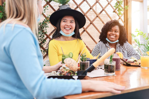 istock Happy multiracial young friends eating at brunch restaurant during coronavirus outbreak - Focus on asian girl 1307217603