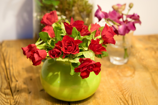 A bouquet of red roses on a wooden table