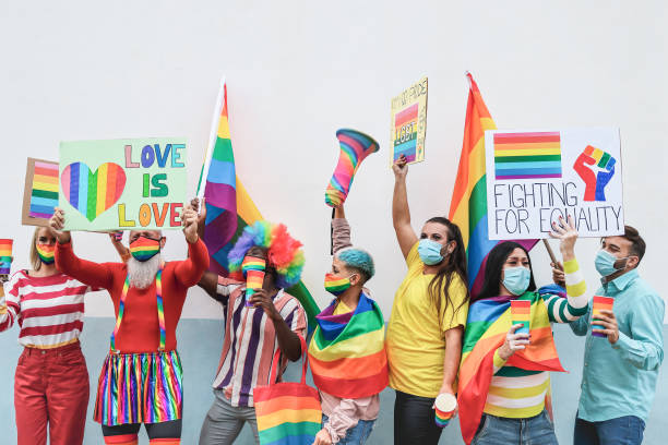 istock Multiracial gay people at lgbt pride event while wearing protective face masks - Focus on faces 1307217805