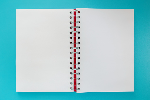 Blank spiral notebook on blue background