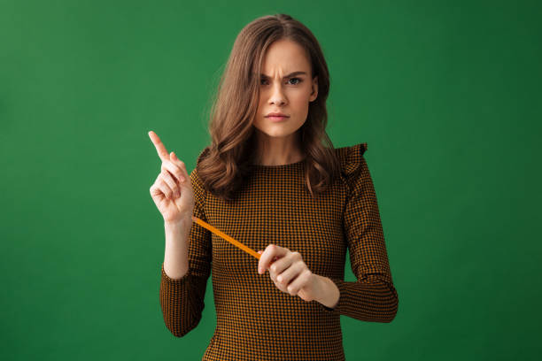 istock Serious young woman looking camera holding pencil. 1307218083