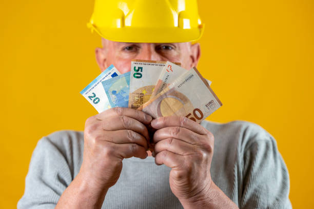 istock worker with yellow helmet showing euro 1307218340