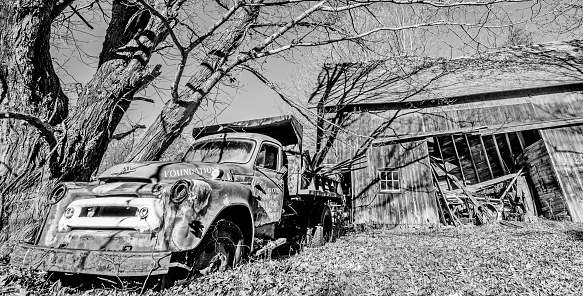 Monroe, CT, USA - Nov 3rd 2015: Vintage truck decaying outside a broken down barn in rural Connecticut, New England, USA