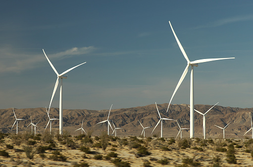 A field of large white windmills in the desert of Southern California again dark blue sky.