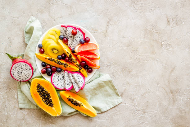 istock Mix of tropical fruit in white plate. Overhead view 1307221947