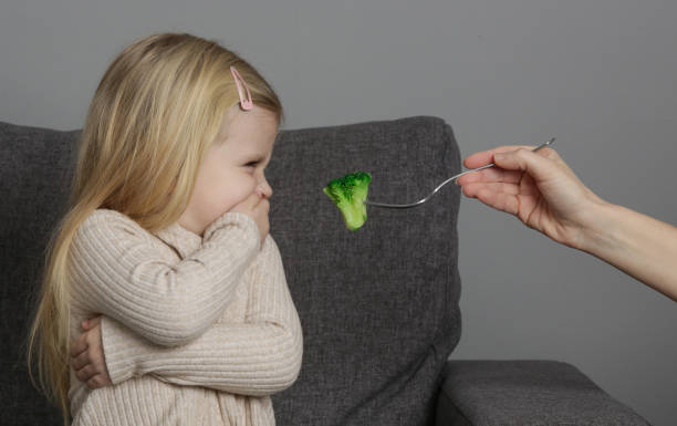 kleines mädchen will keinen brokkoli essen. kind weigert sich, gemüse zu essen. - eating obsessive child toddler stock-fotos und bilder