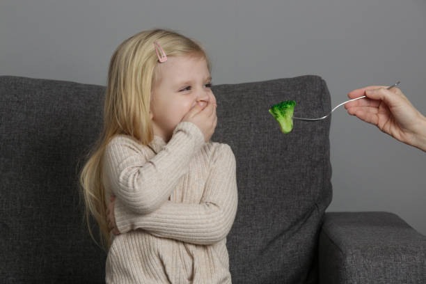 kleines mädchen will keinen brokkoli essen. kind weigert sich, gemüse zu essen. - eating obsessive child toddler stock-fotos und bilder