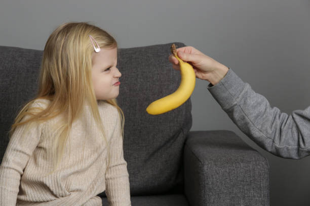 kleines mädchen will keine bananen essen. kind weigert sich, früchte zu essen. - eating obsessive child toddler stock-fotos und bilder