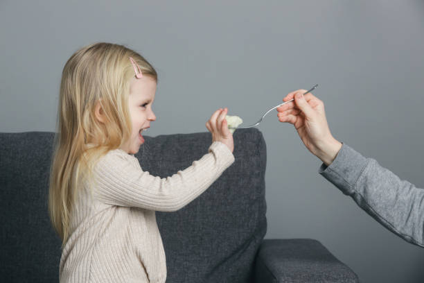 kleines mädchen will keinen blumenkohl essen. kind weigert sich, gemüse zu essen. - eating obsessive child toddler stock-fotos und bilder