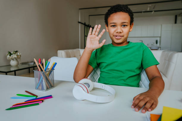 istock Boy waving hand and say hello watching online lesson 1307224498