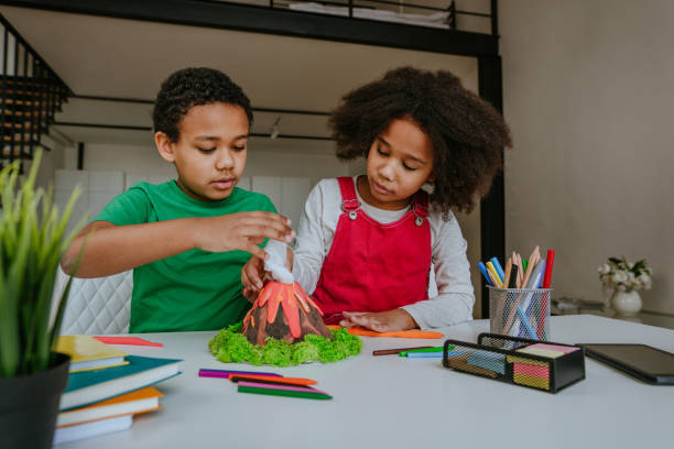 istock Children making DIY volcano model from kids play clay 1307224528
