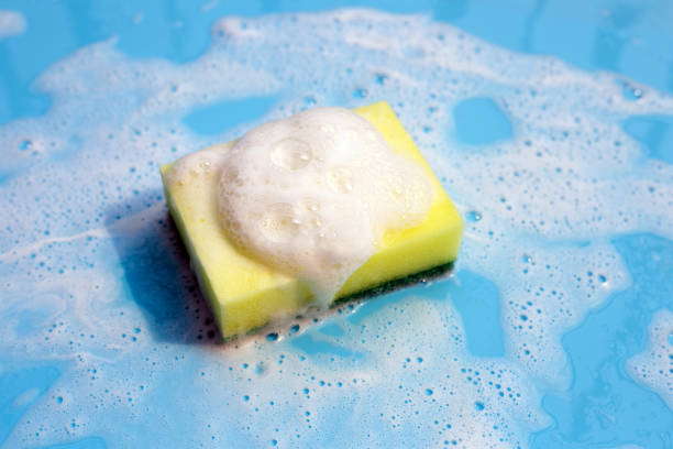 istock Dishwashing sponge with foam on blue background. 1307225303