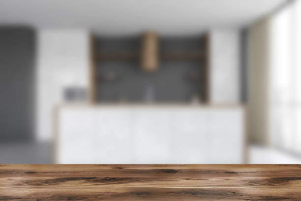 istock Wooden desk on foreground, kitchen set with table blurred 1307226959