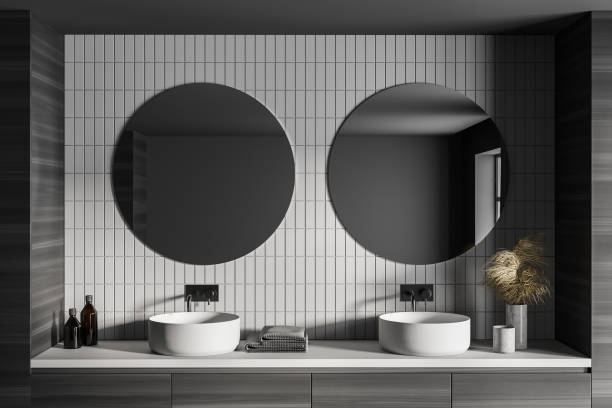 istock Two white sinks and towels in grey bathroom with mirrors on brick wall 1307227604