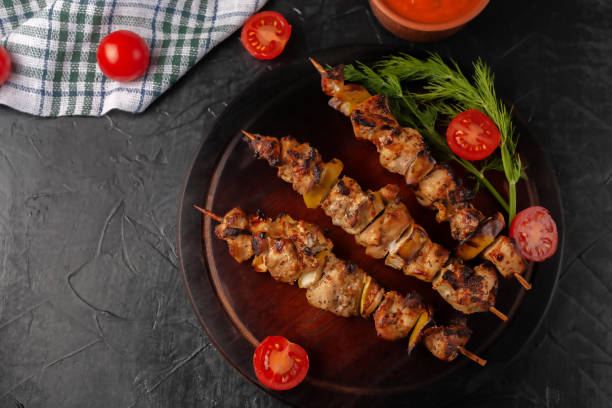 istock Chicken skewers with apples and vegetables on a black background 1307227681