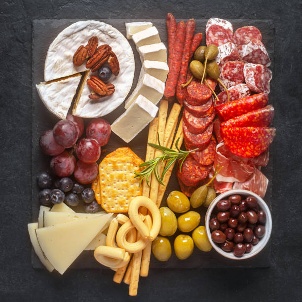 istock Charcuterie board with spanish jamon, capers, fuet, cheese and berries 1307227744