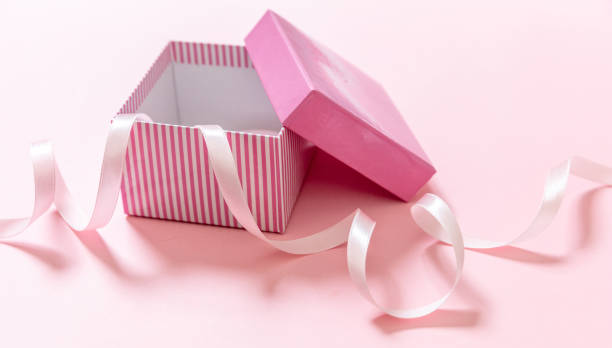 istock Gift box open and ribbon on pink background. Birthday present concept. 1307229962