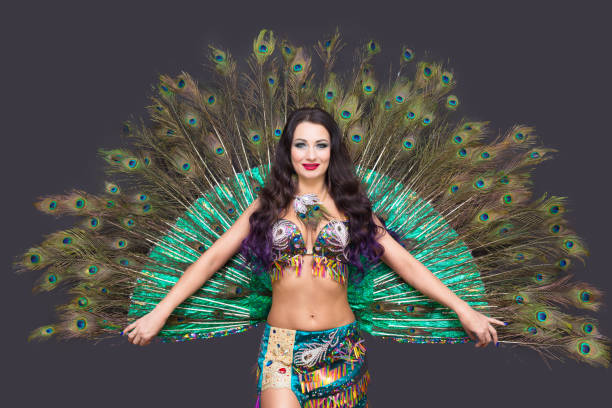 istock Dancer holds peacock feathers in her hands, black background view from the back 1307231027