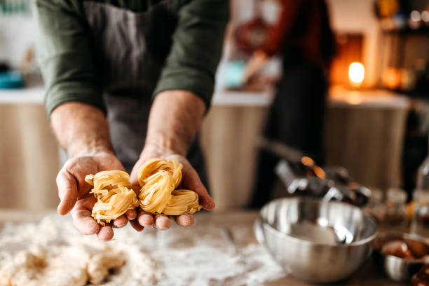 Unrecognisable senior chef holding pasta in his hands