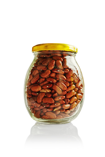 Close up view of raw red beans in a jar isolated on white background.