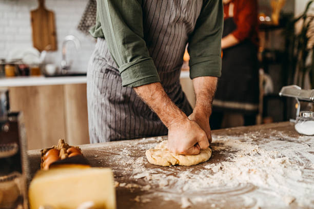 istock Close up of male baker hands kneading dough 1307231477