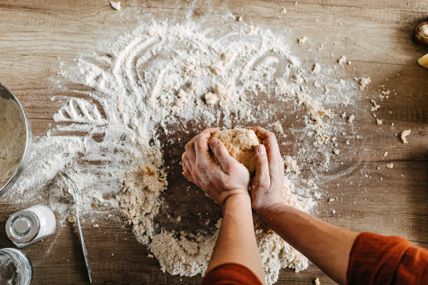 istock Close up of male baker hands kneading dough 1307231526