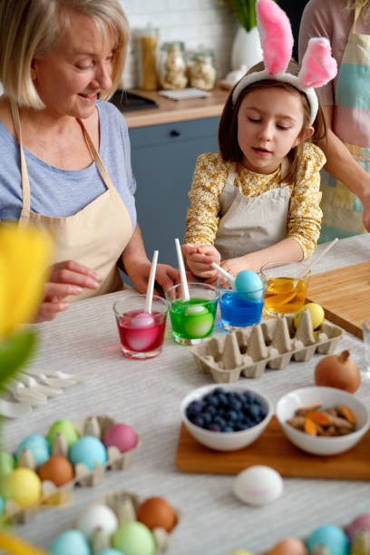 istock Little girl coloring Easter eggs with grandmother 1307235099