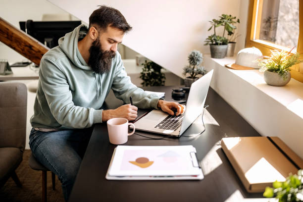 istock Young bearded man working on his laptop 1307235855