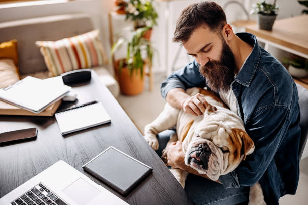 istock Young bearded man working from home with his dog 1307236144