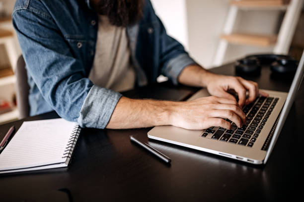istock Young casually clothed man working on a laptop 1307236328