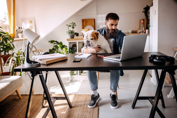 istock Young freelancer working from home with dog in his lap 1307237093