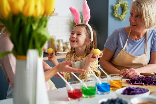istock Little girl have fun during coloring Easter eggs with family 1307237925