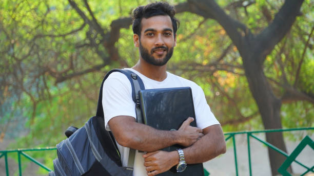 istock young man with laptop and bag at college campus 1307238130