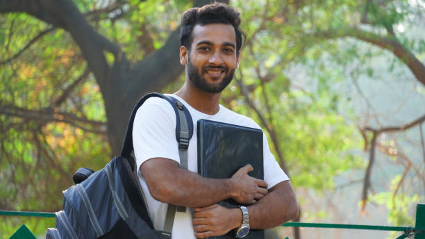 istock Cheerful Young student with laptop looking 1307238144