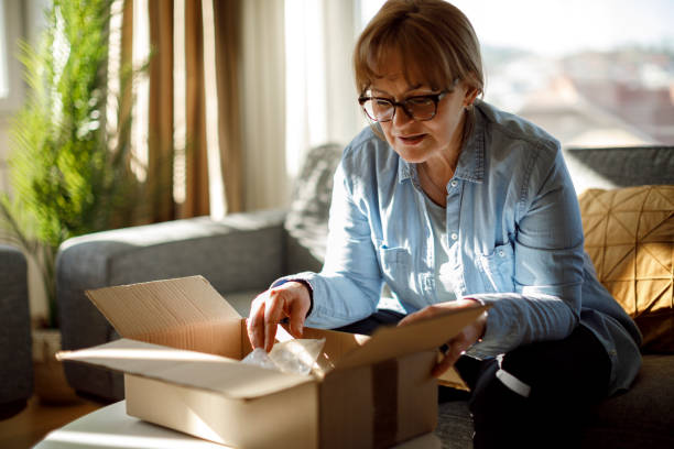istock Excited senior woman opens package delivery 1307238150