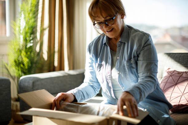 istock Excited senior woman unpacking online order 1307238228