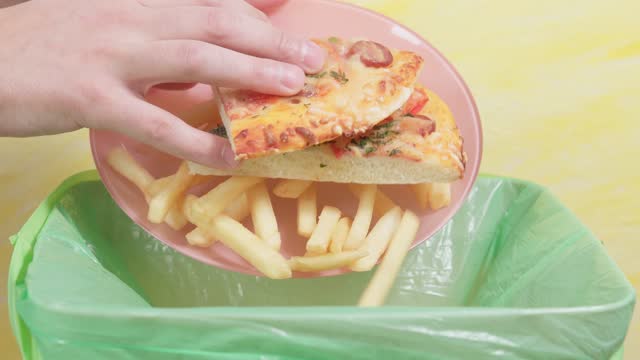 throws junk food, French fries, and pizza in the trash.