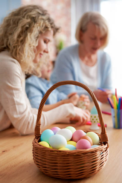 istock Basket full of Easter eggs and women decorate the eggs 1307238553