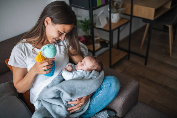 istock Young mother playing with her newborn son while relaxing at home. 1307239750