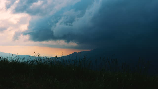 Time lapse. Thick thunderstorm clouds float over mountainous territory.