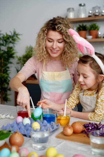 istock Mom and daughter dyeing Easter eggs in the kitchen 1307240707