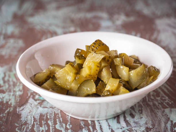 Sliced pickled cucumber in a deep plate, preparation for salad Sliced pickled cucumber in a deep plate, preparation for salad close-up vinegar stock pictures, royalty-free photos & images