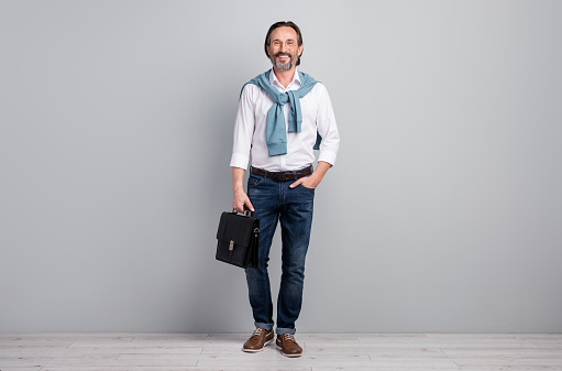 Full length body size photo of businessman wearing white shirt keeping leather bag isolated on pastel grey color background.