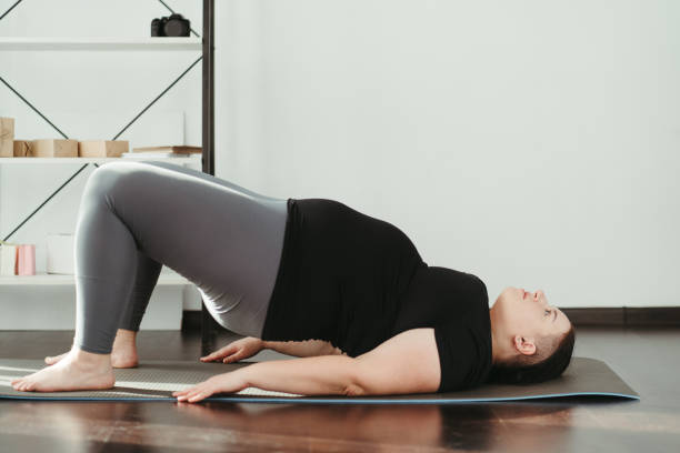 istock Overweight woman doing physical exercises at home 1307241255