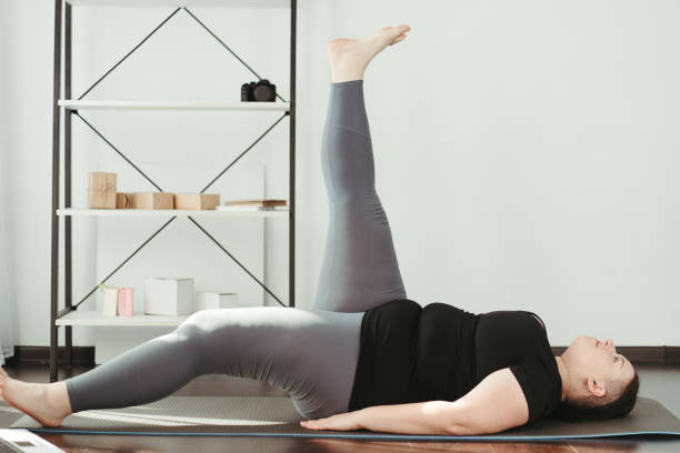 istock Overweight woman doing physical exercises at home 1307241266