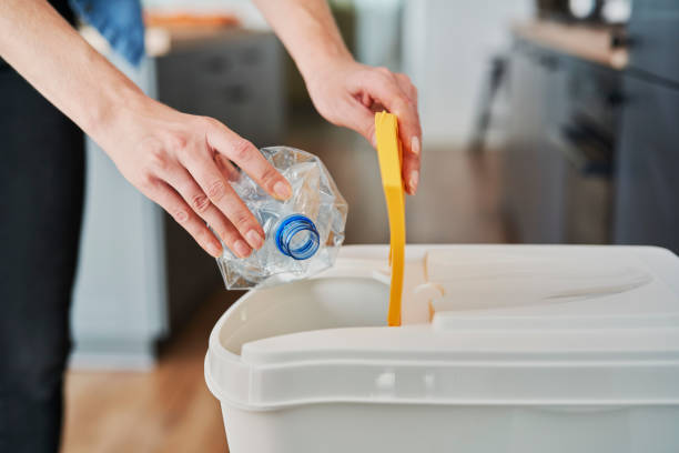 istock Woman throwing away plastic bottles into the bin 1307242684